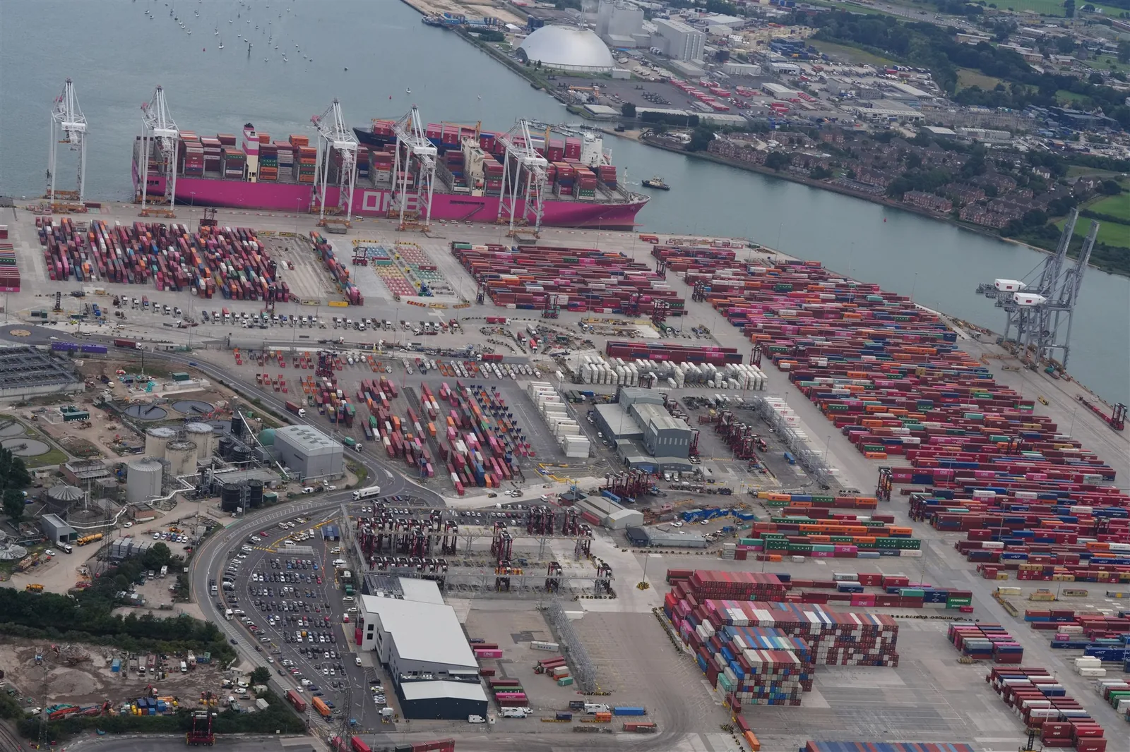 Aerial photograph of a container port, cargo ship, cranes and logistics yard
