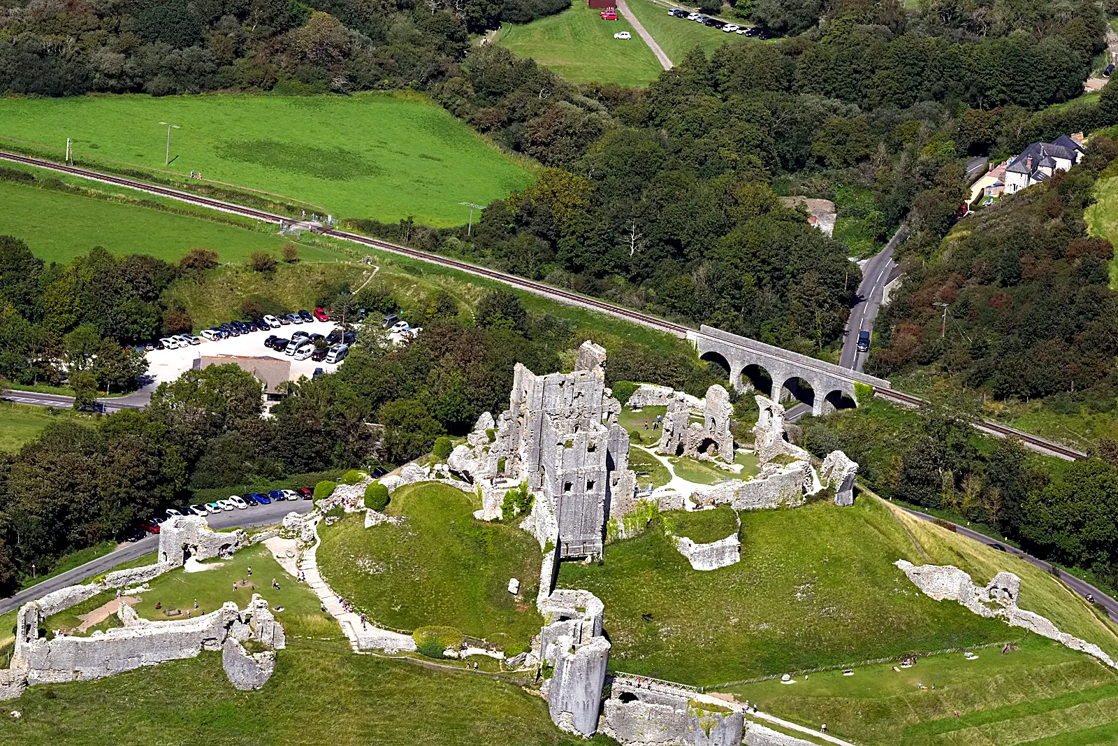 Aerial photograph of Corfe Castle ruins on its hill above the Purbeck countryside, Dorset