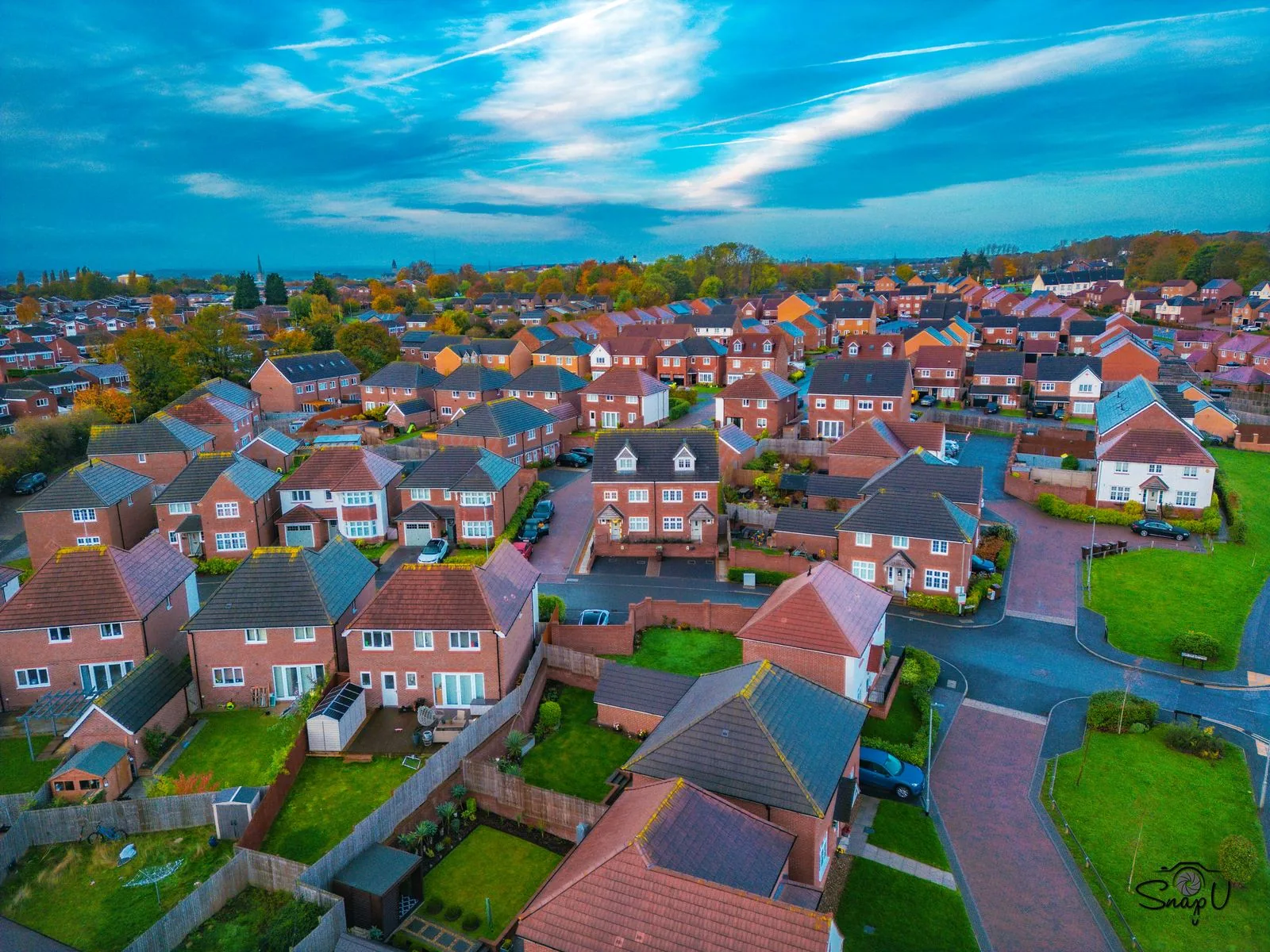 Golden hour drone photograph of a UK housing estate at sunset