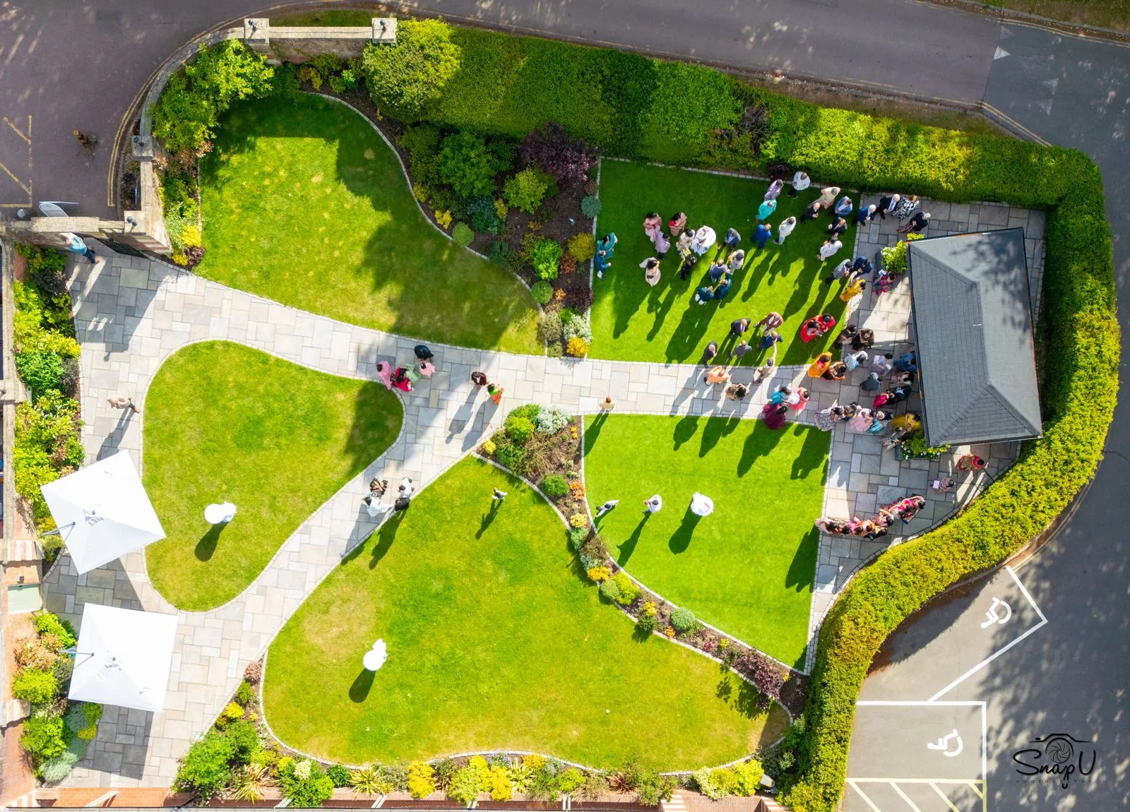 Overhead aerial photo of an outdoor garden event with marquees and guests