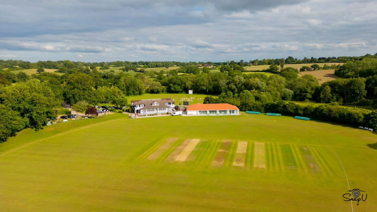 Aerial drone photograph of a sports club pavilion and cricket grounds UK